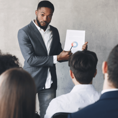 Technical Project Manager image: a businessperson leads a demonstration in front of an audience.