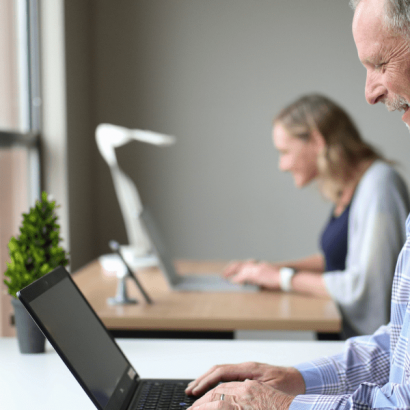 Consultant - Clinical Analyst image: People are working on their computers at their desks.